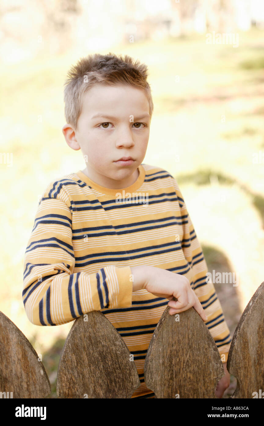 Young boy looking over fence hi-res stock photography and images - Alamy