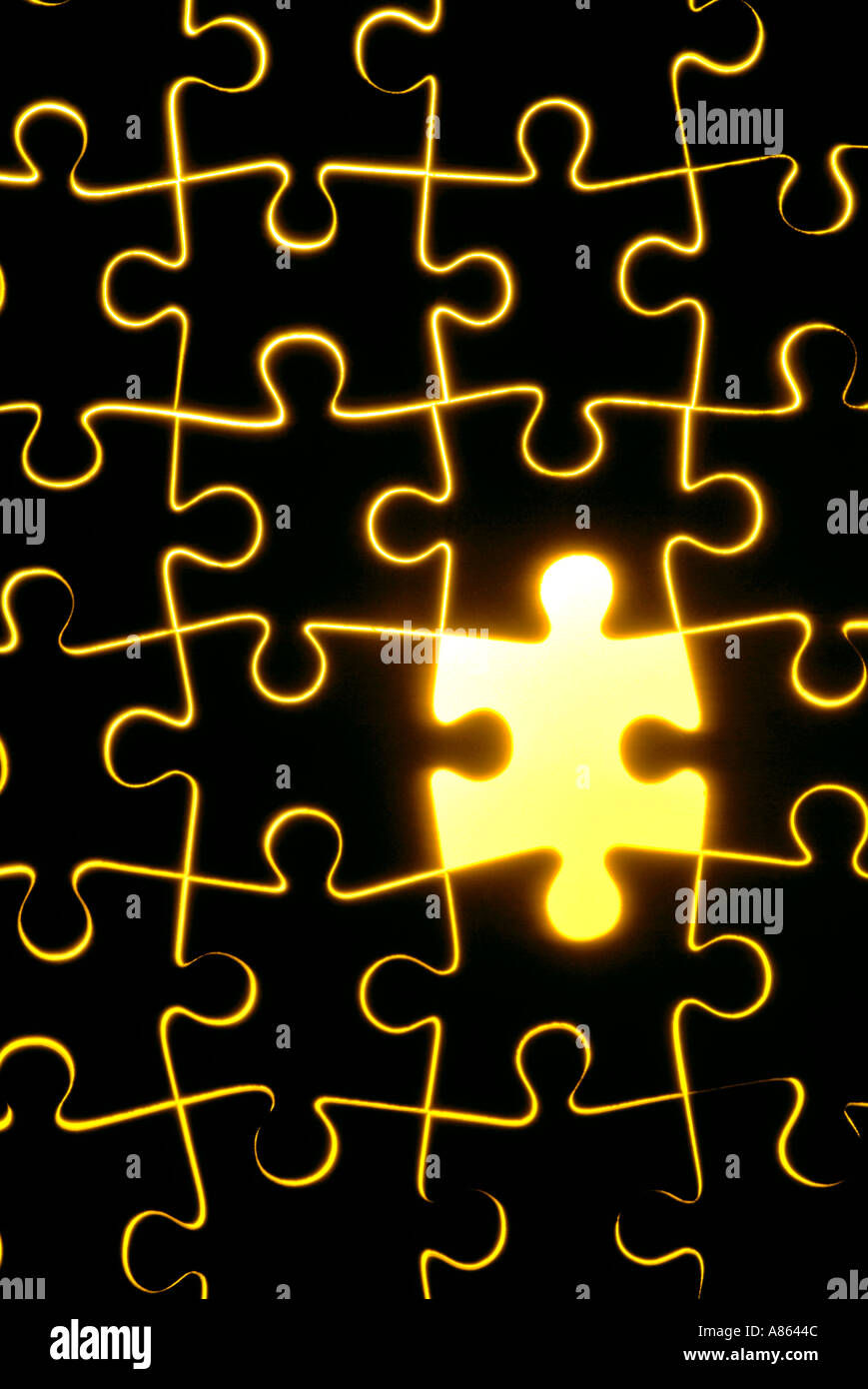 wooden jigsaw with one piece removed with yellow backlight Stock Photo