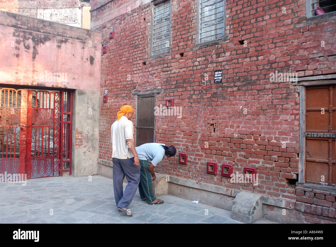 Tourists looking at marks of bullet holes at Jalianwala Baug , Amritsar , Punjab , India Stock Photo