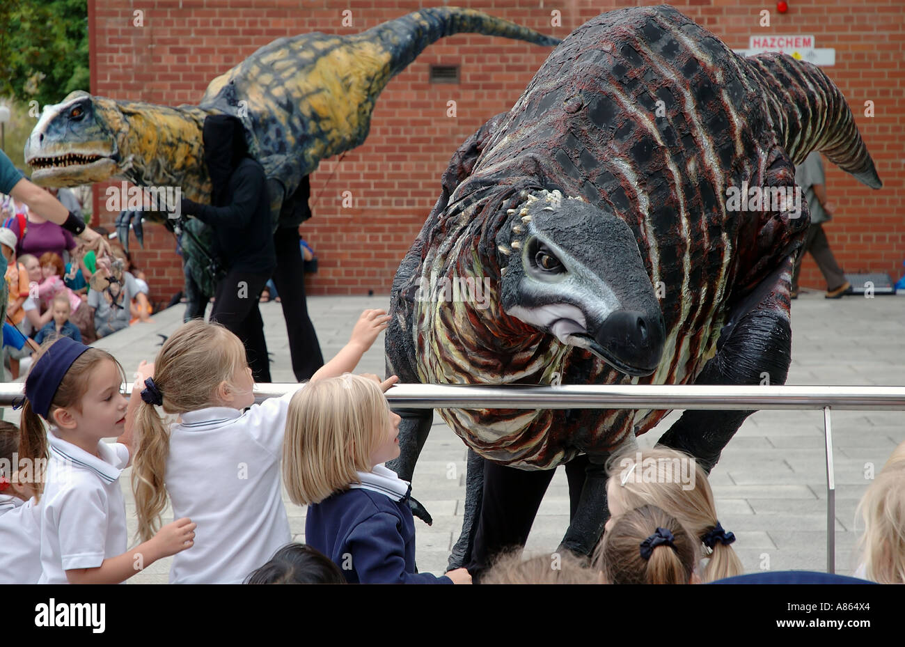 Schoolchildren meet lifesized mobile dinosaur puppets at the Western Australian Museum Stock Photo
