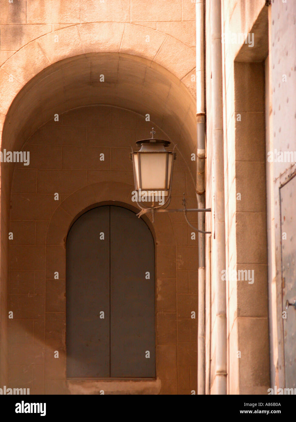 Street lamp against arched door in Old town Girona Spain Stock Photo