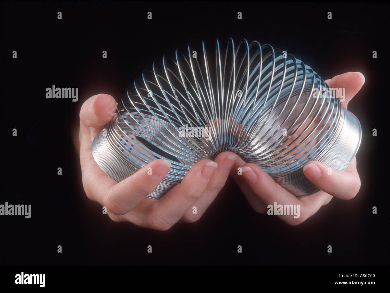 hands holding a slinky toy Stock Photo