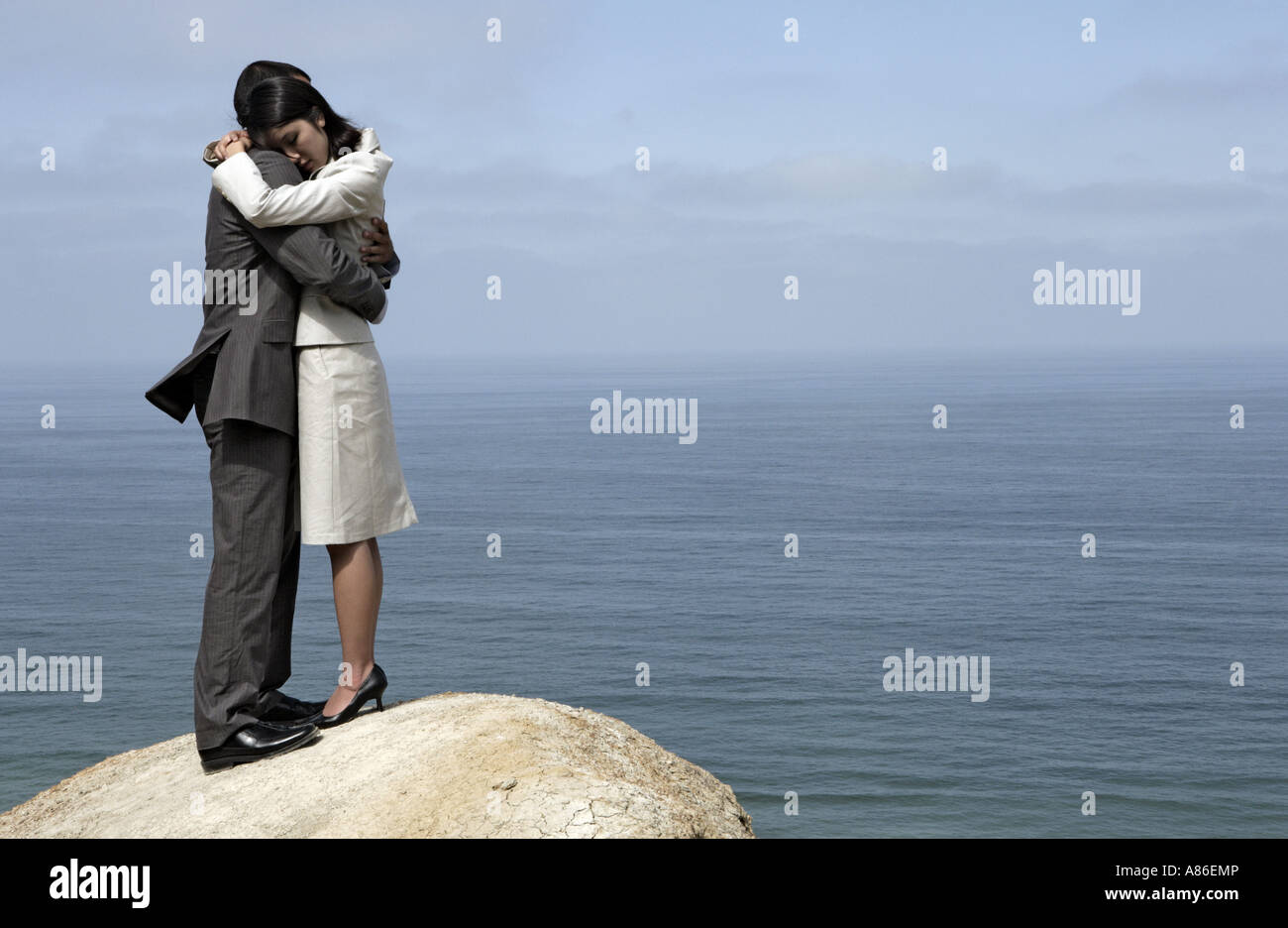 View of a couple hugging each other on a cliff Stock Photo - Alamy