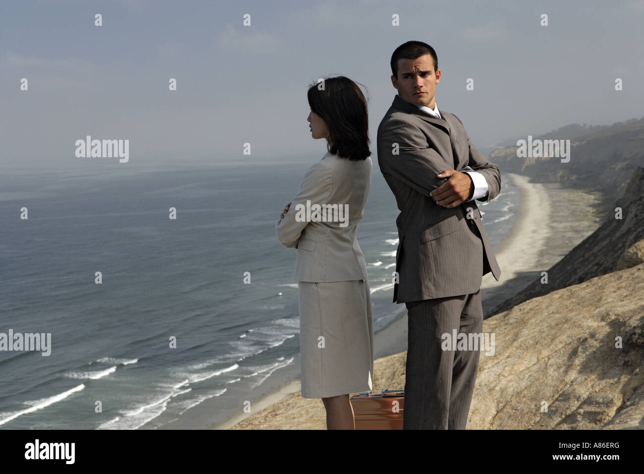View of a man and a woman standing on a cliff. Stock Photo