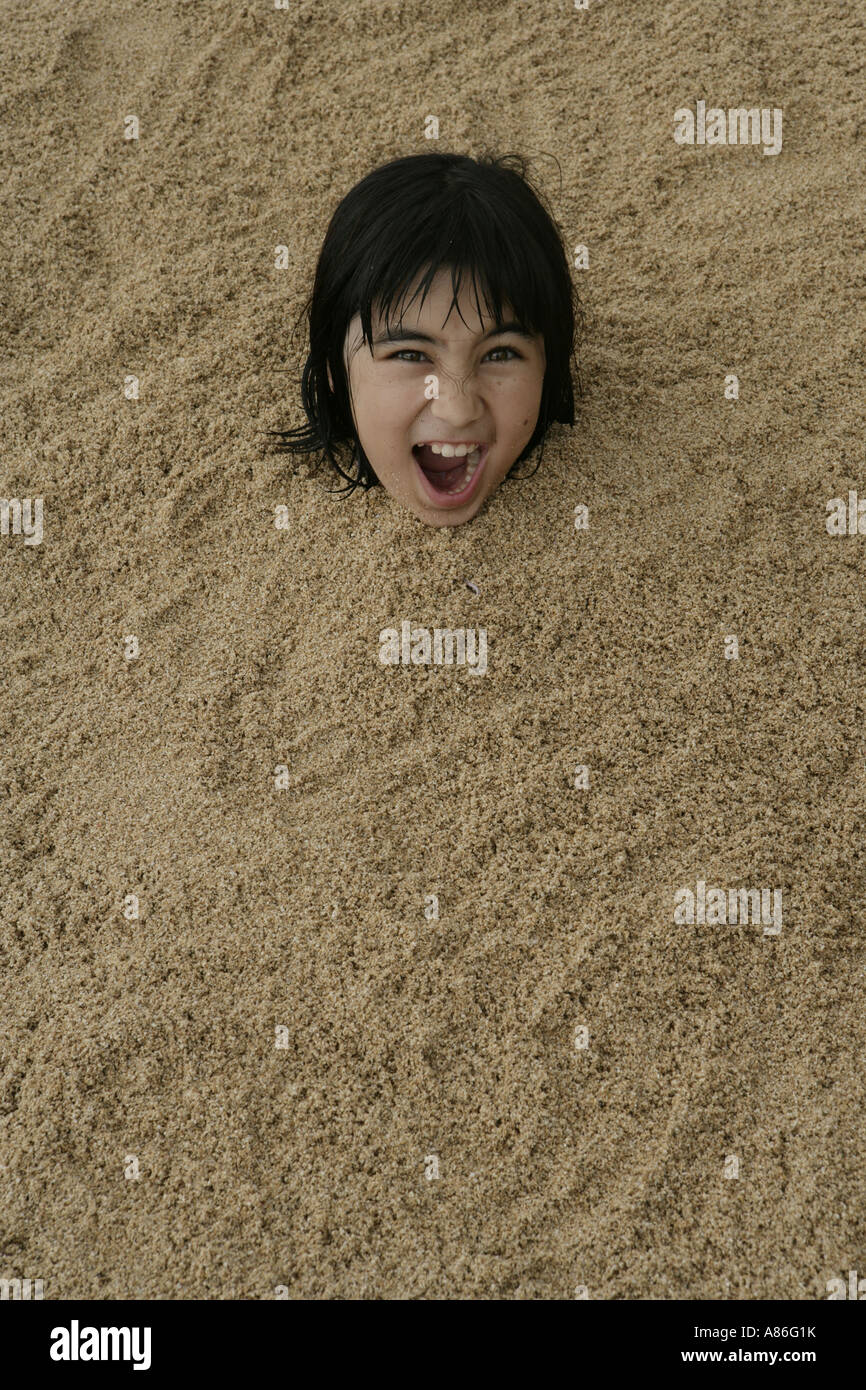 View of a girl buried in sand Stock Photo Alamy