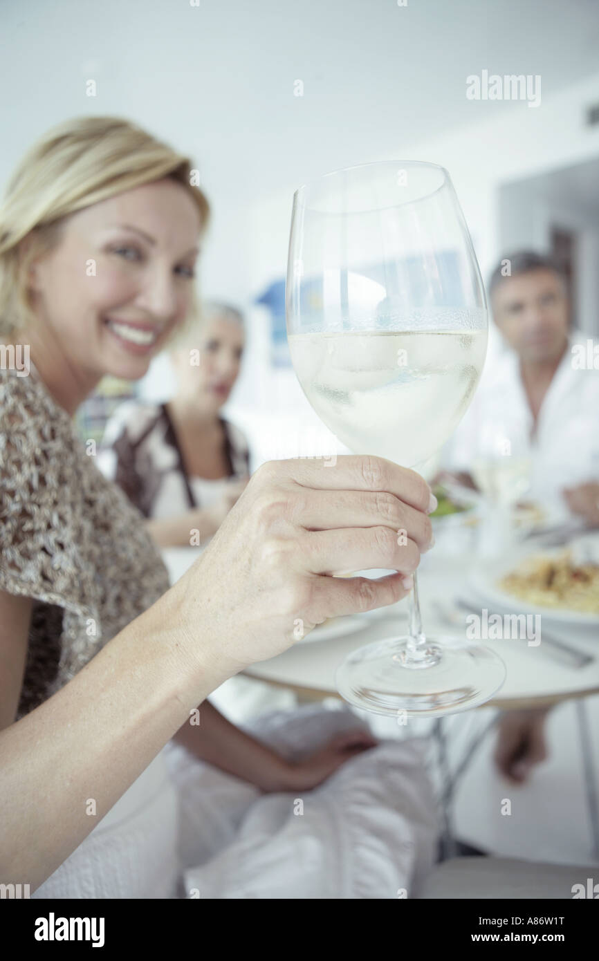 Women holding up a wine glass among a group Stock Photo - Alamy