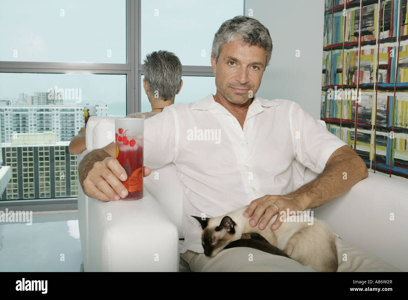 Two Mature Adults Sitting Back To Back In A Chairs Stock Photo