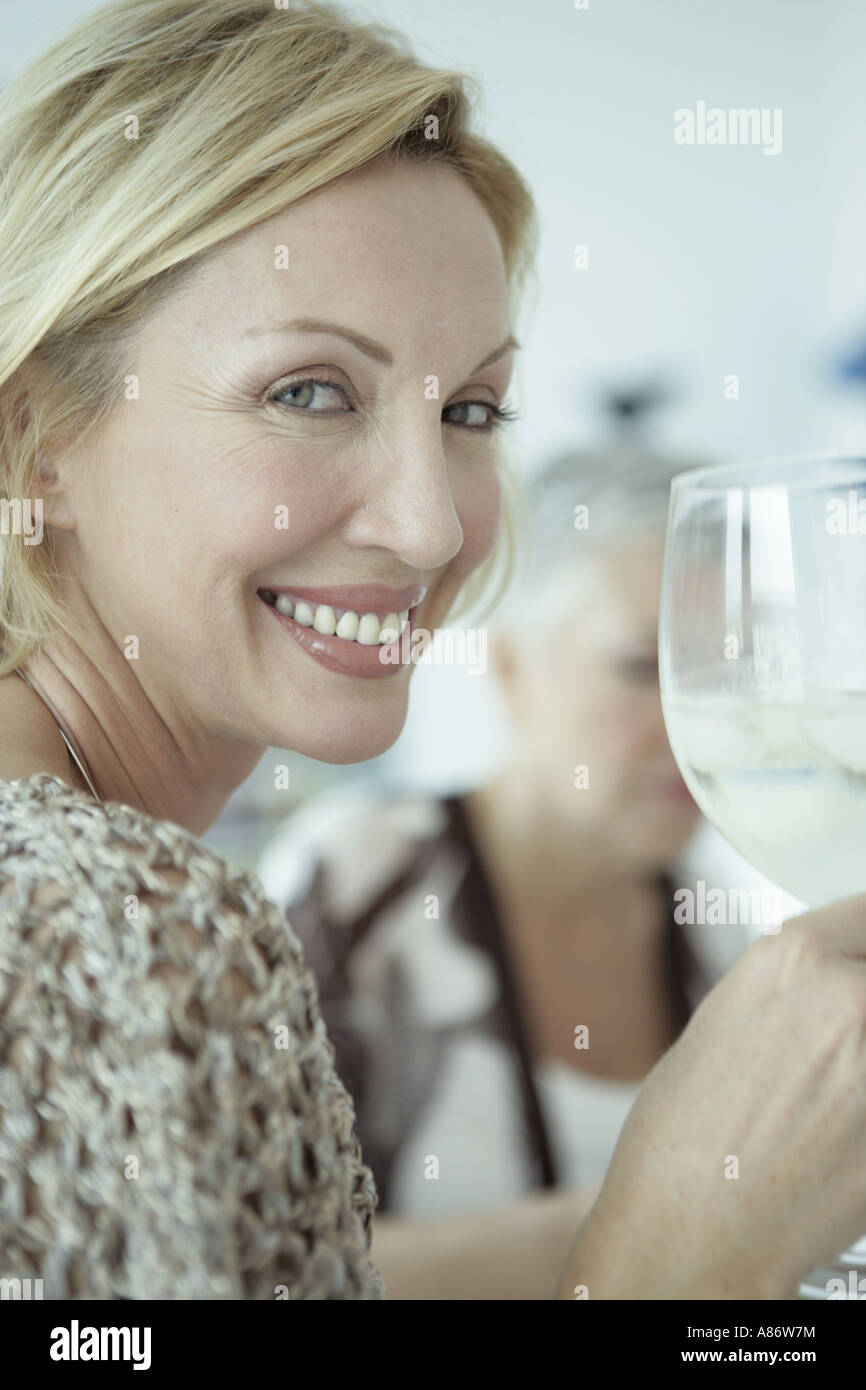 Woman smiling and holding a glass of wine hi-res stock photography and ...
