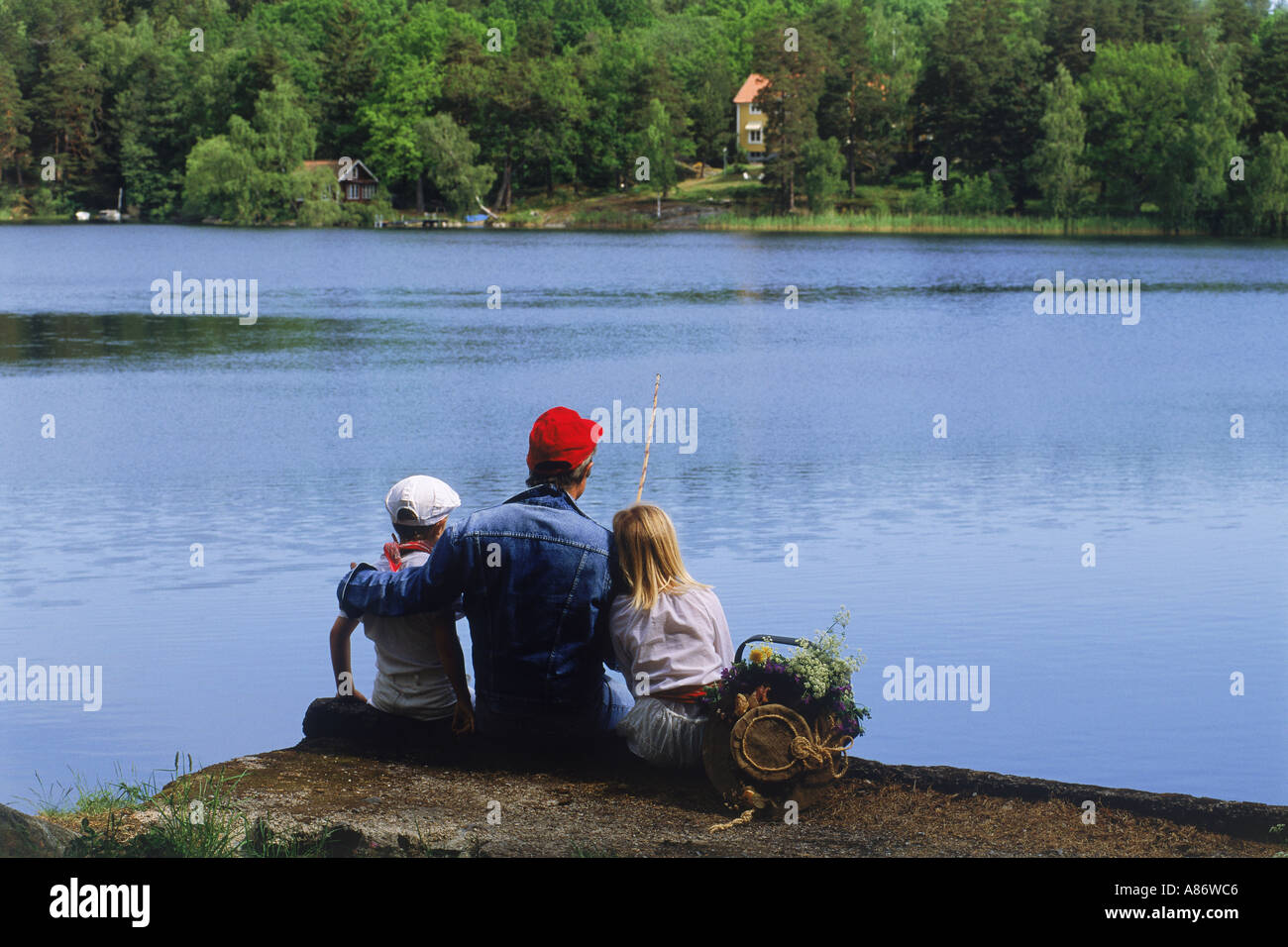 Dad and kids on lakeside fishing picnic in Sweden during summer Stock Photo