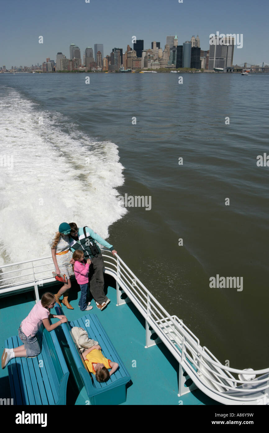 Family of five on a boat with city buildings in the background Stock Photo