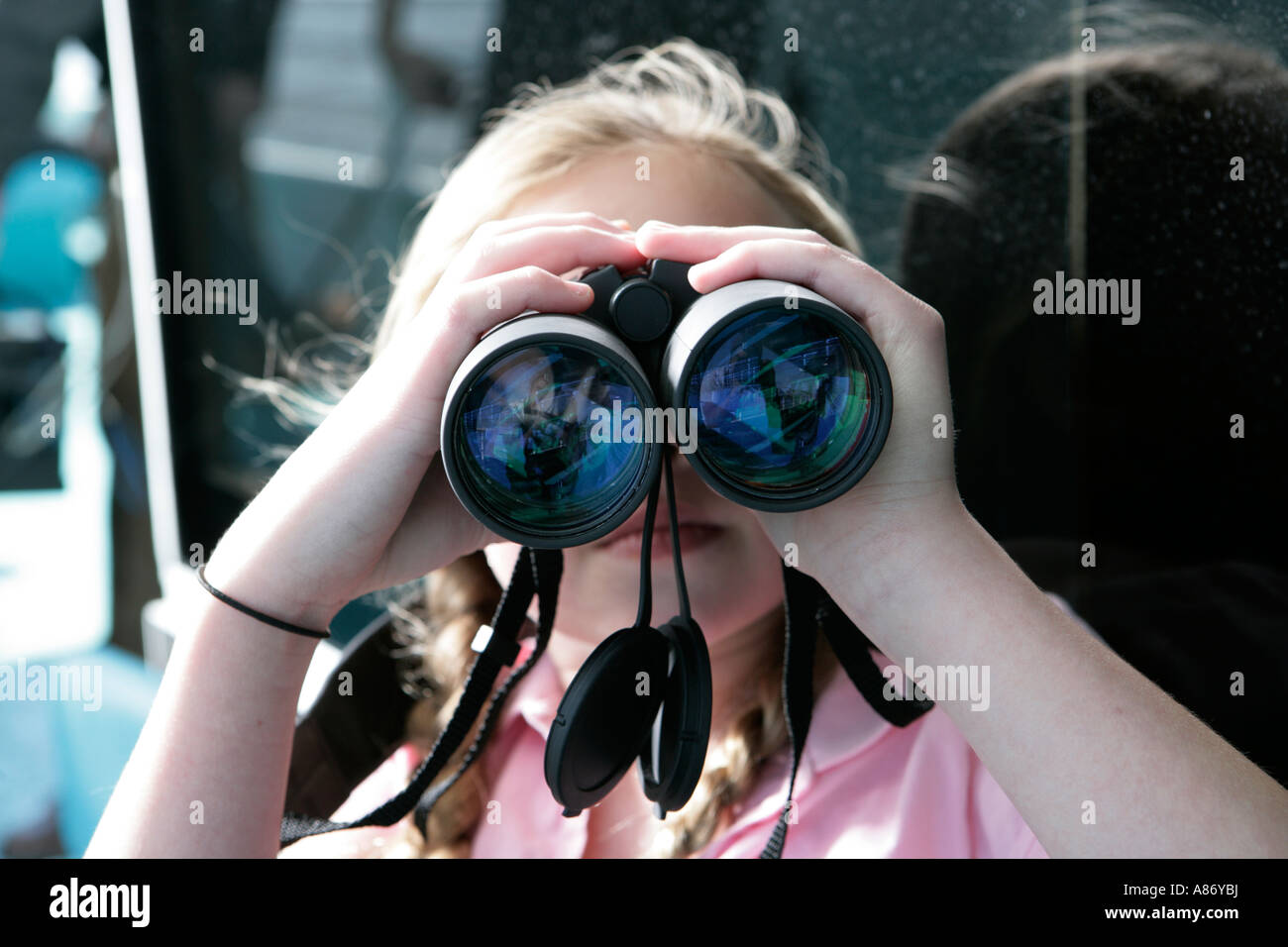 Little girl using binoculars Stock Photo
