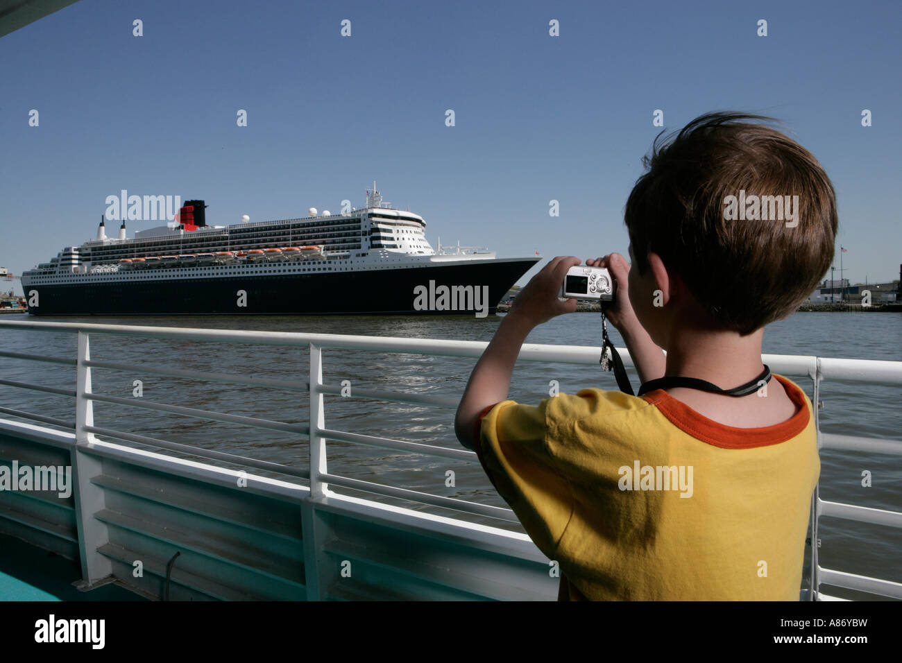 Little boy taking a picture of a cruise ship Stock Photo