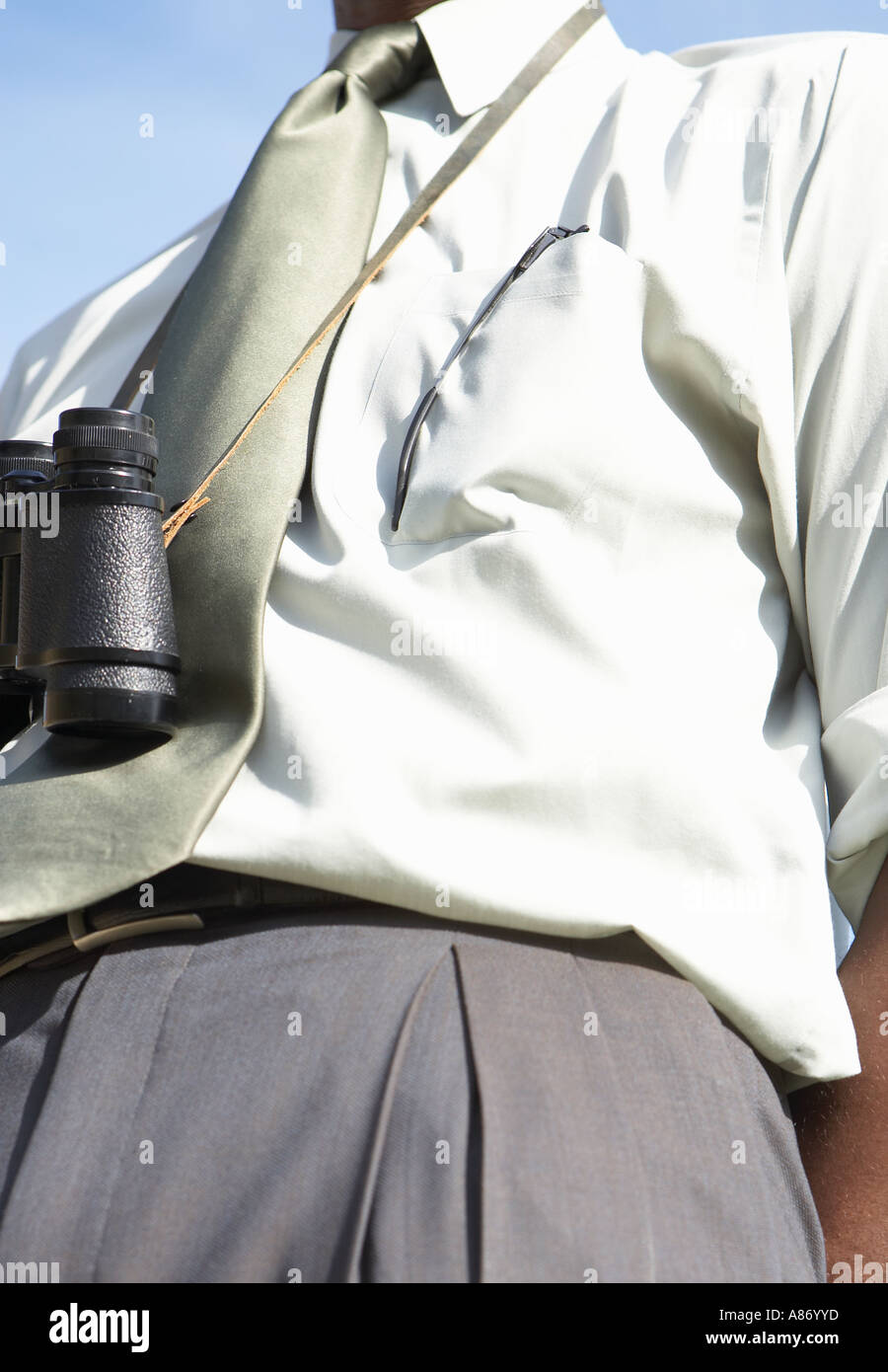 business man in shirt and tie with binoculars hanging  around his neck Stock Photo