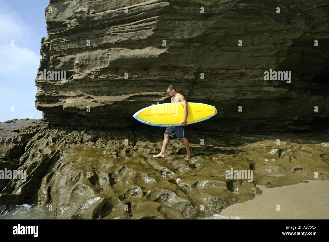 View of a man walking with a surfboard Stock Photo - Alamy