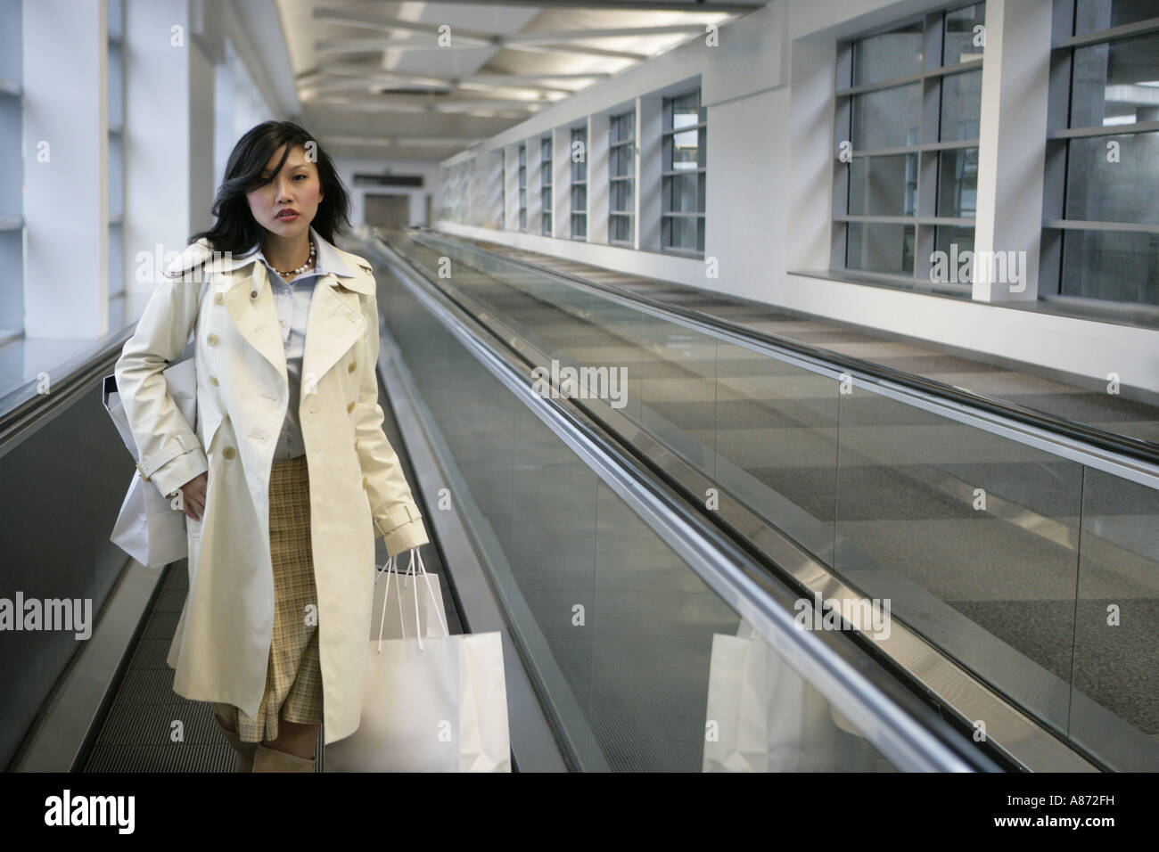 A young woman is walking on a conveyor belt Stock Photo Alamy