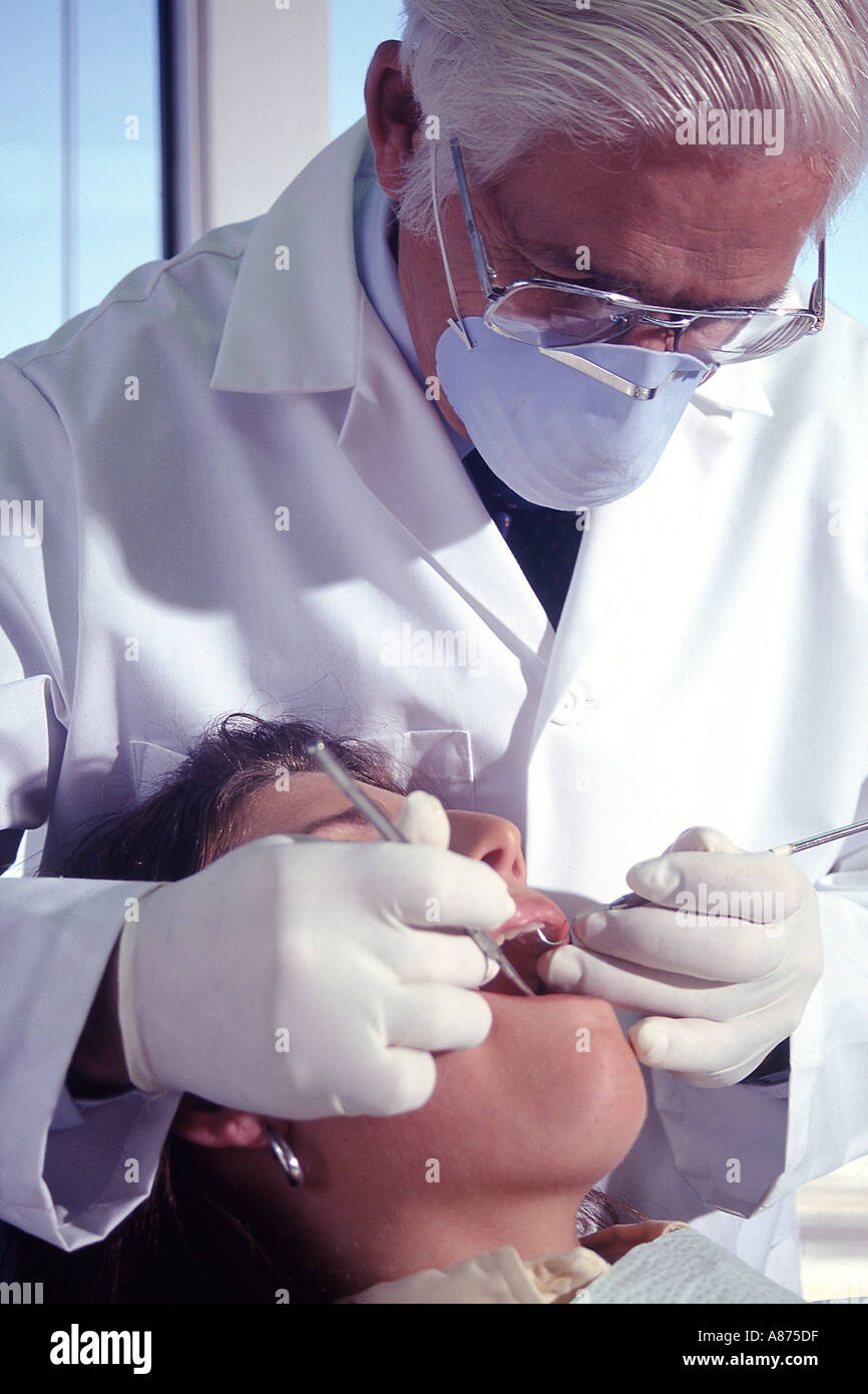 Male dentist examining patient's teeth Stock Photo