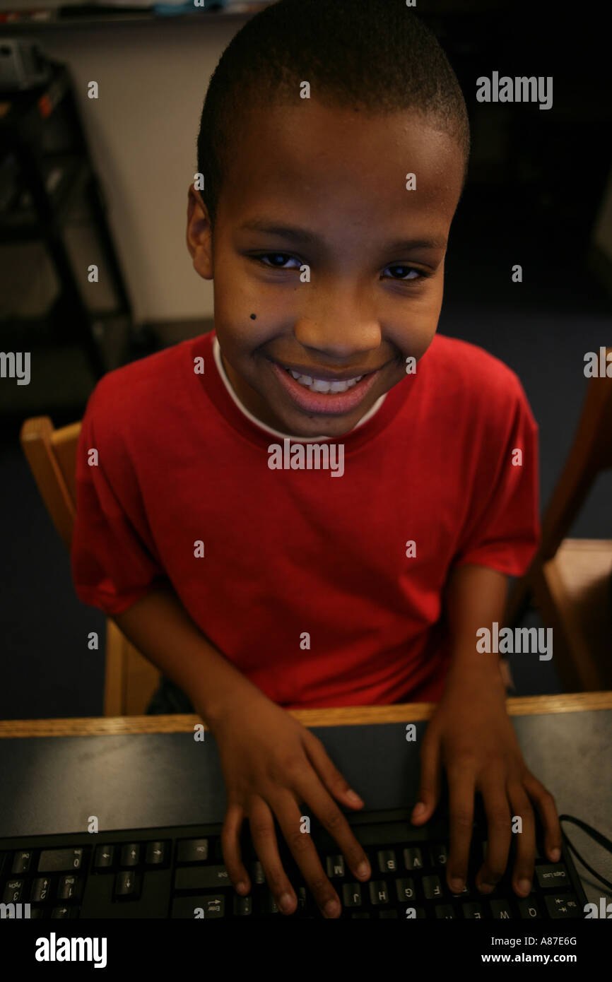 Boy (5-7) smiling with hands on keyboard, portrait Stock Photo