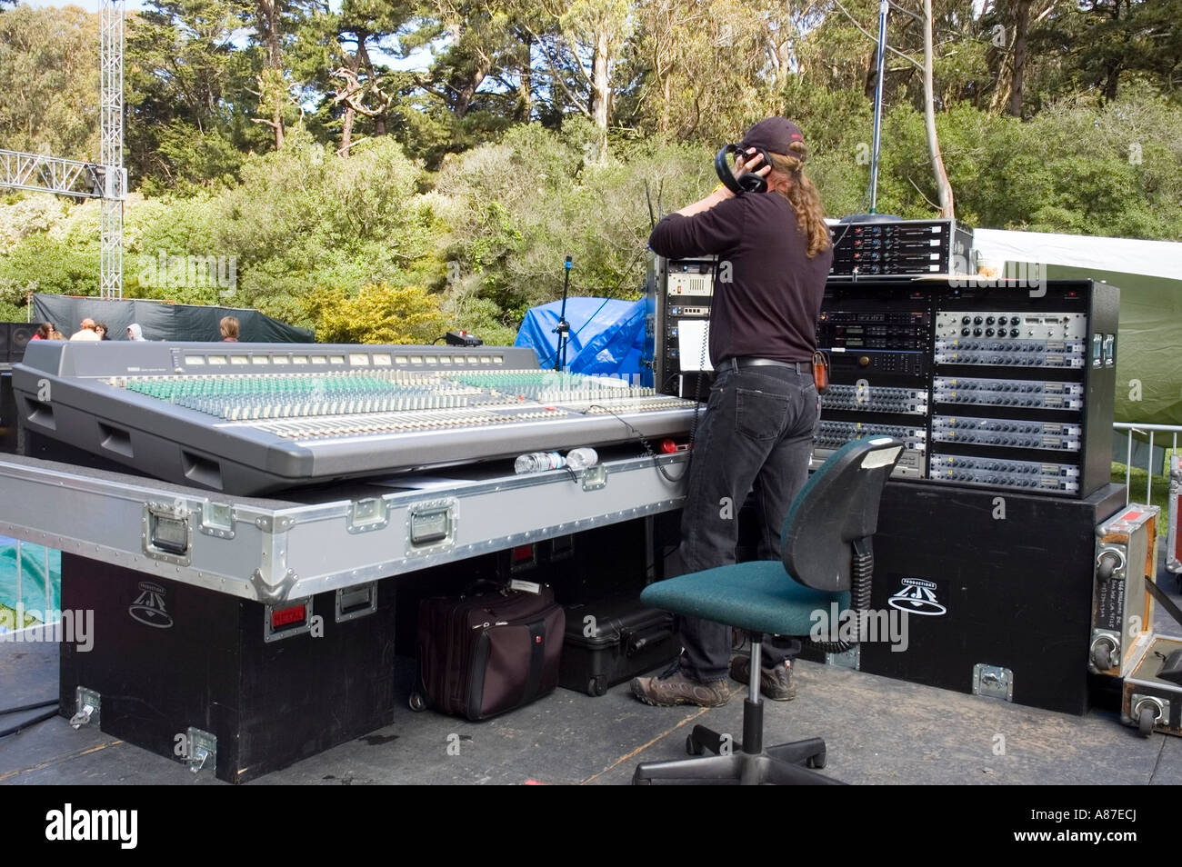 Sound technician prepares an audio console for an outdoor concert Stock