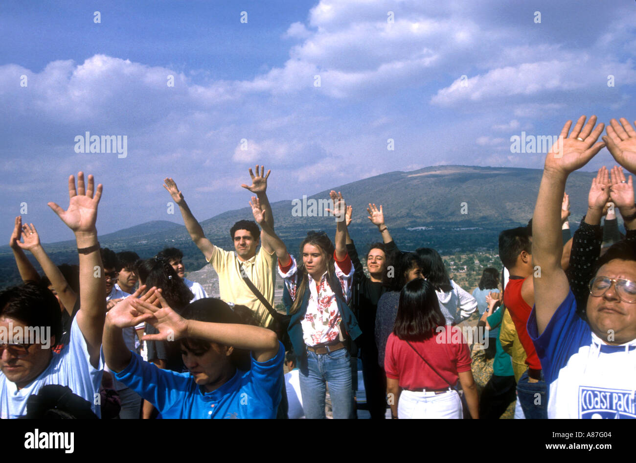 People receiving energy with their arms up on first January on the top of the Pyramid of the sun, Mexico Stock Photo