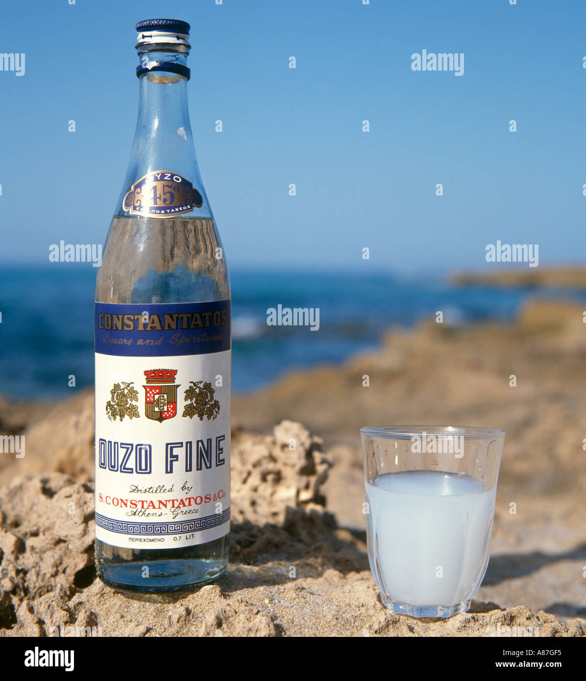 Bottle and glass of Ouzo on the beach, Greece Stock Photo