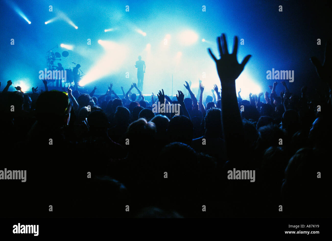 Crowd with hands in the air at a gig Stock Photo