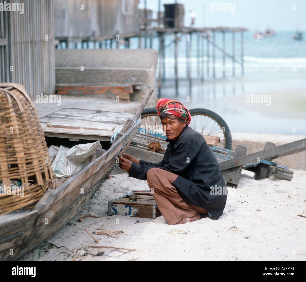 Local man mending boat in Hua Hin, Thailand Stock Photo