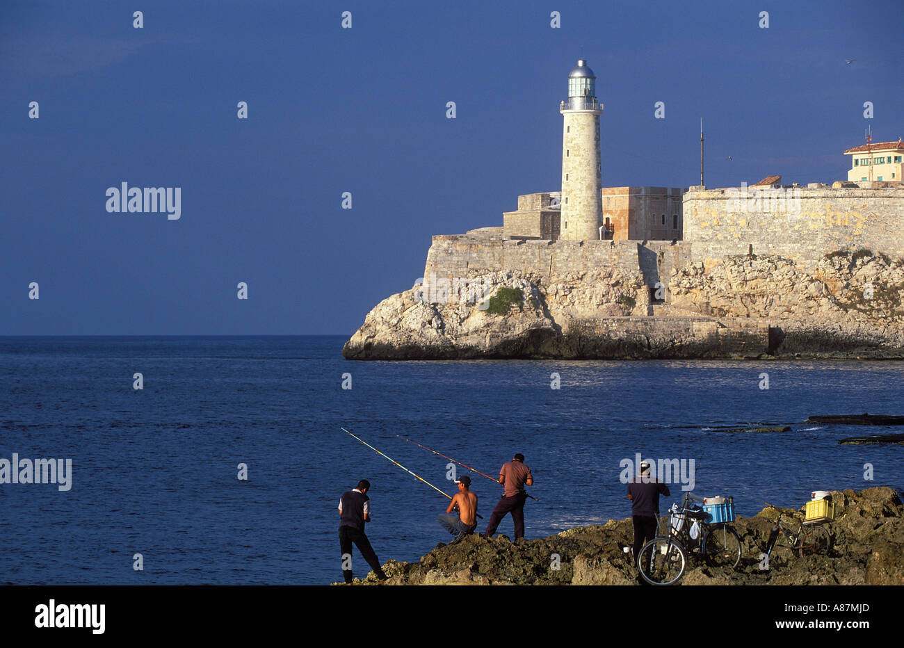 people fishing Castiolio do los Tre Reyes del Morro beyond the Malecon Havana Cuba Stock Photo