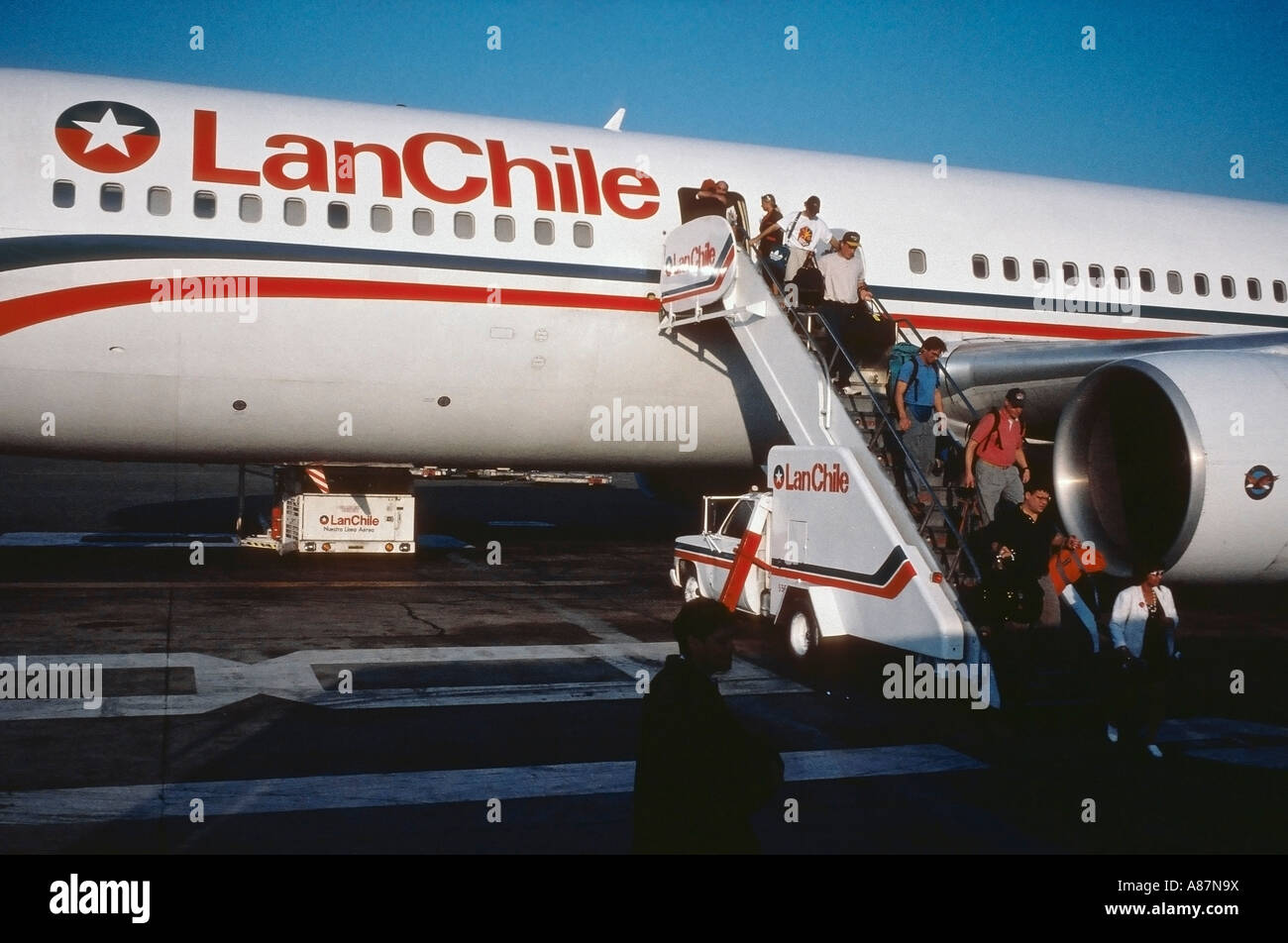 Passengers disembark from a Lan Chile Airlines plane at the Santiago