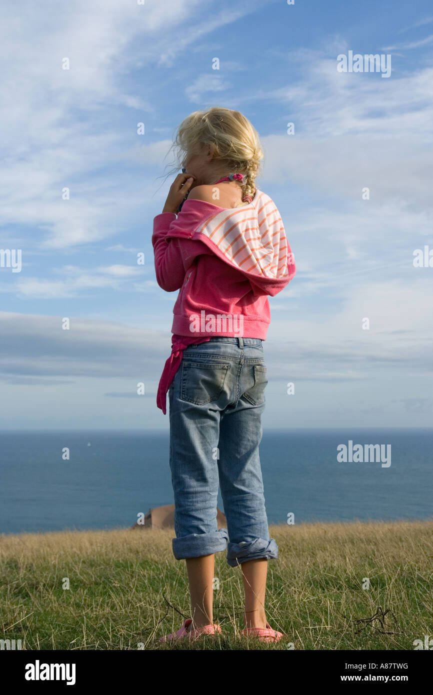 Young girl in field with blue sky Stock Photo - Alamy