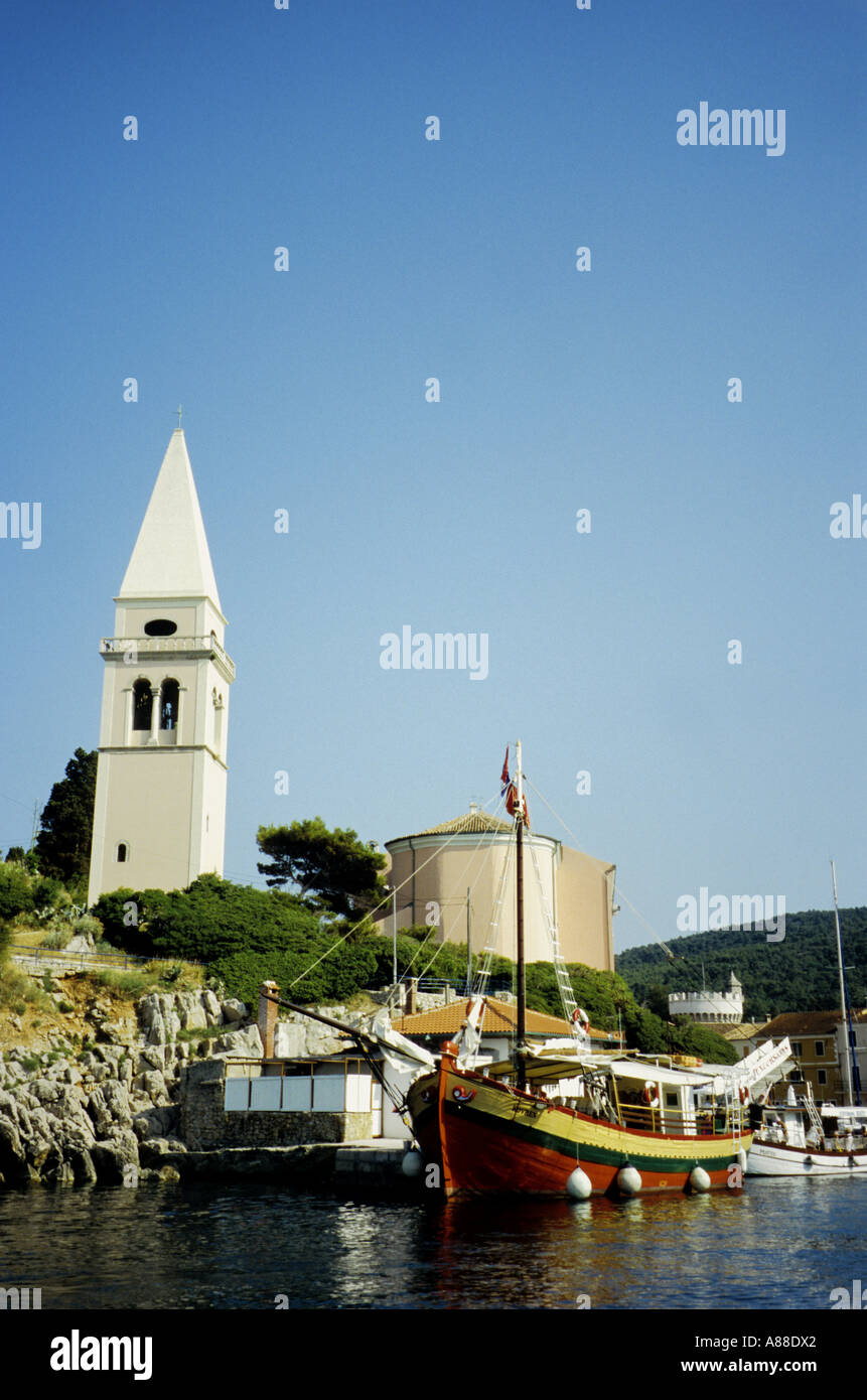 Bell tower of Veli Losinj with crenulated castle in the distance, Veli Losinj, Losinj, Croatia Stock Photo