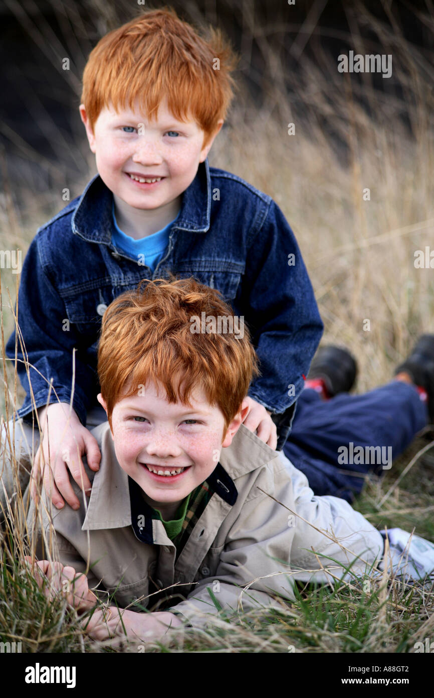 Vertical environmental portrait of two young ginger haired brothers