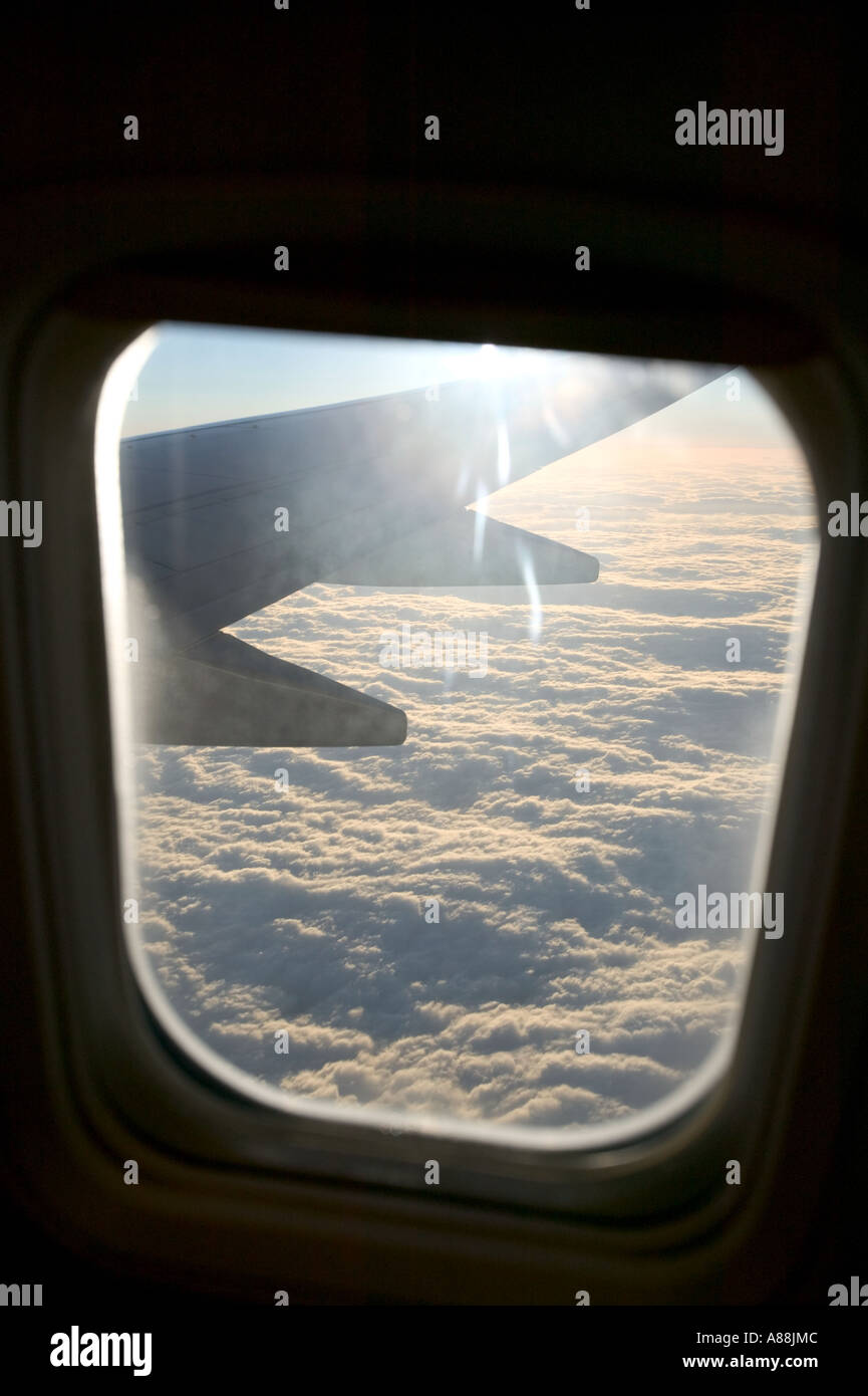 view out of the window of a passenger jet, flying above the clouds ...