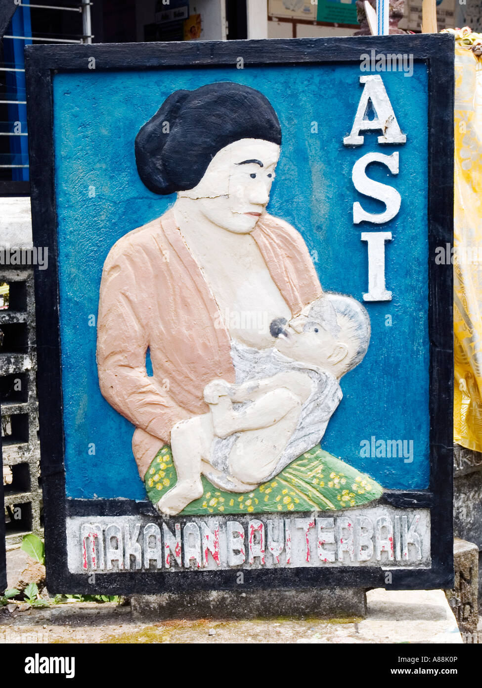 Stone carved sign of mother breastfeeding baby outside of maternity clinic,Munduk village,Bali,Indonesia. Stock Photo