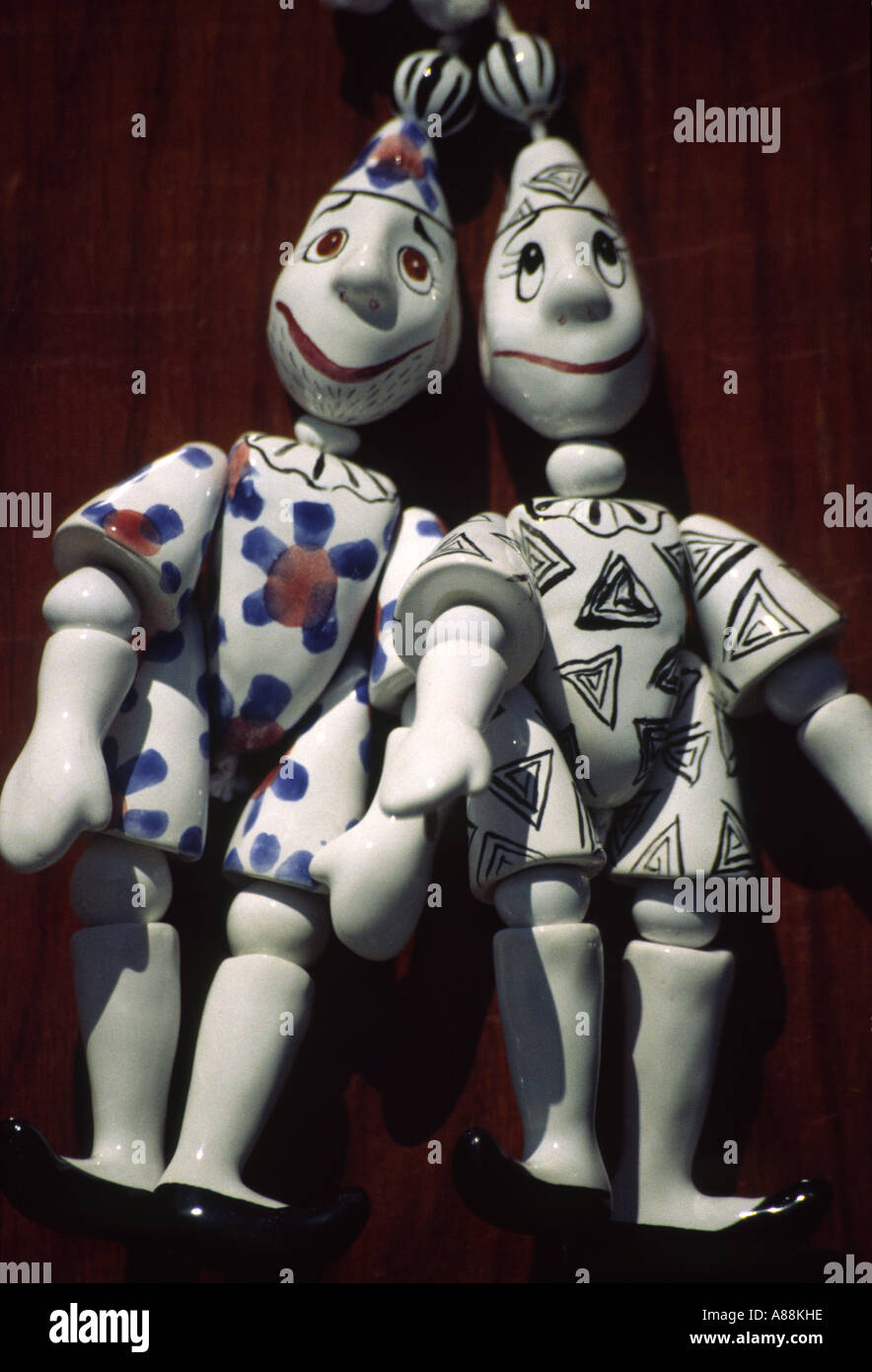 Vertical landscape detail of porcelain puppets hanging for sale on a