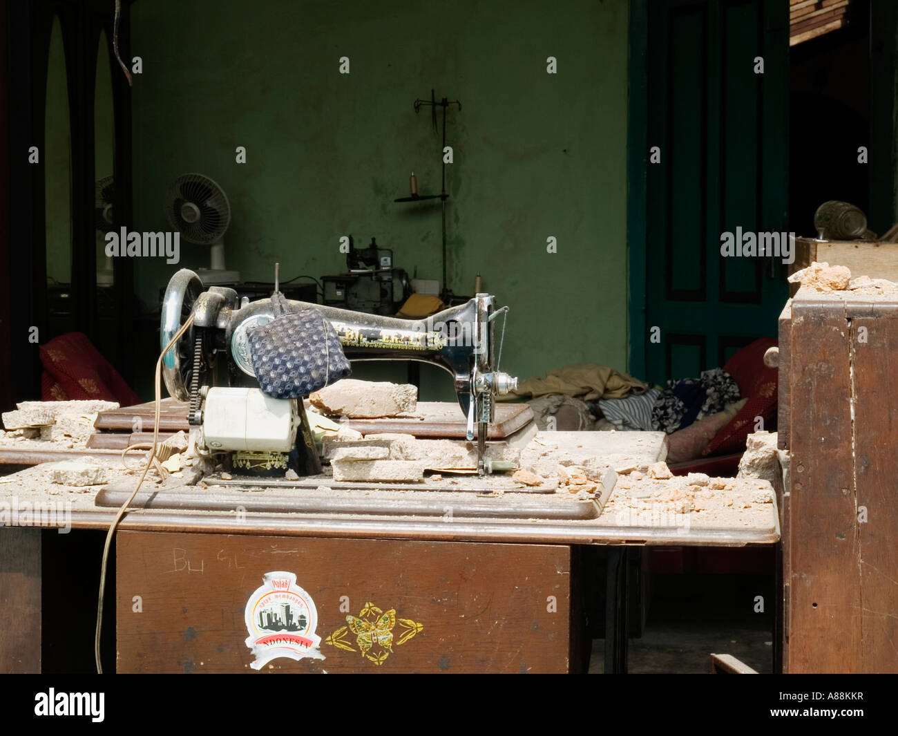 Sewing machine on rubble strewn table hours after the devastating May 2006 earthquake,Yogyakarta,Java,Indonesia. Stock Photo