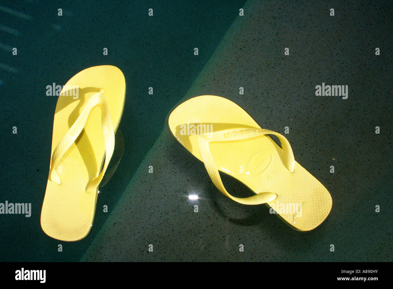 A PAIR OF THONGS BY A POOL BDA10601 Stock Photo - Alamy