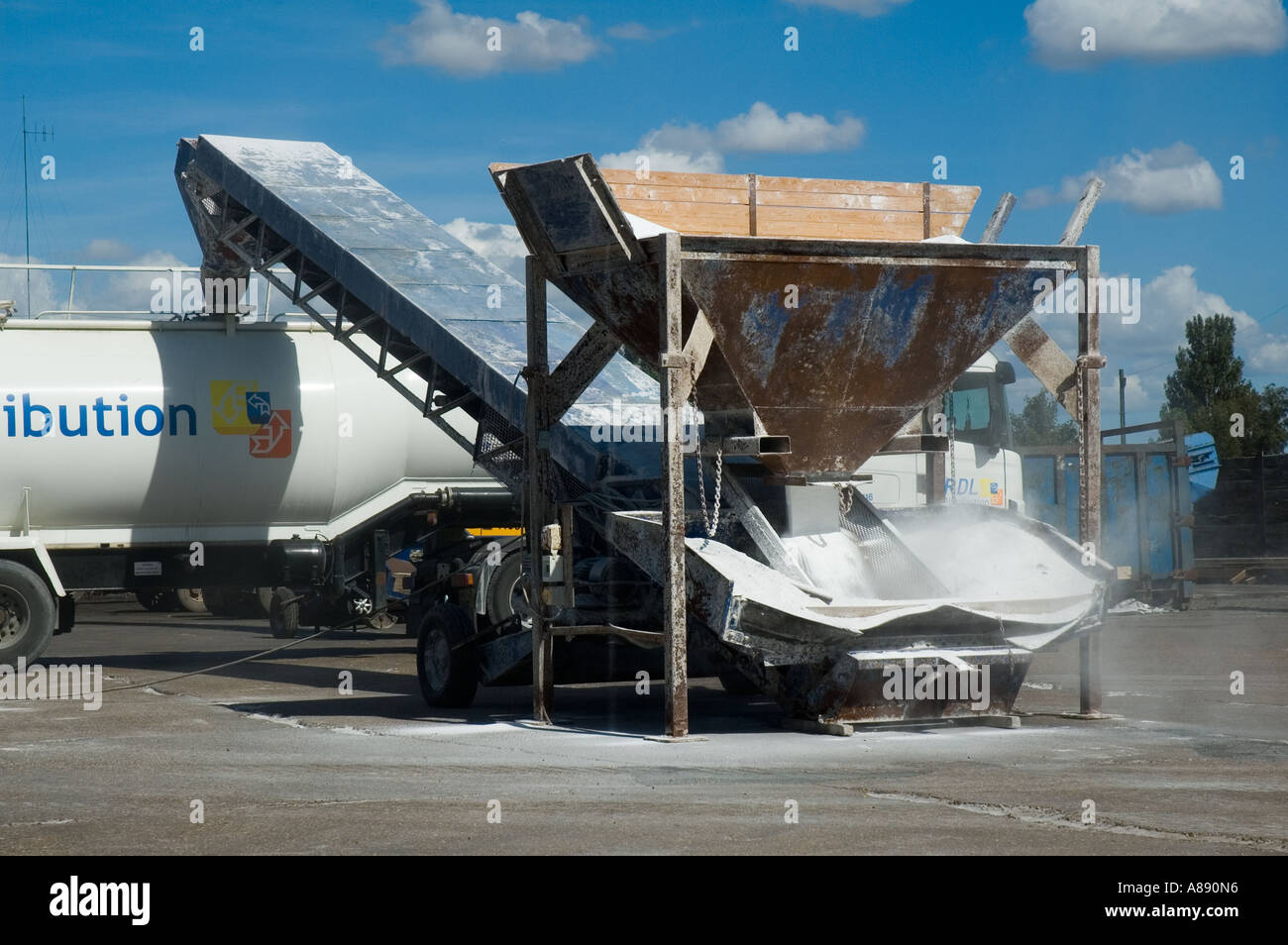 Hopper and conveyor belt system used to load powdered material into a