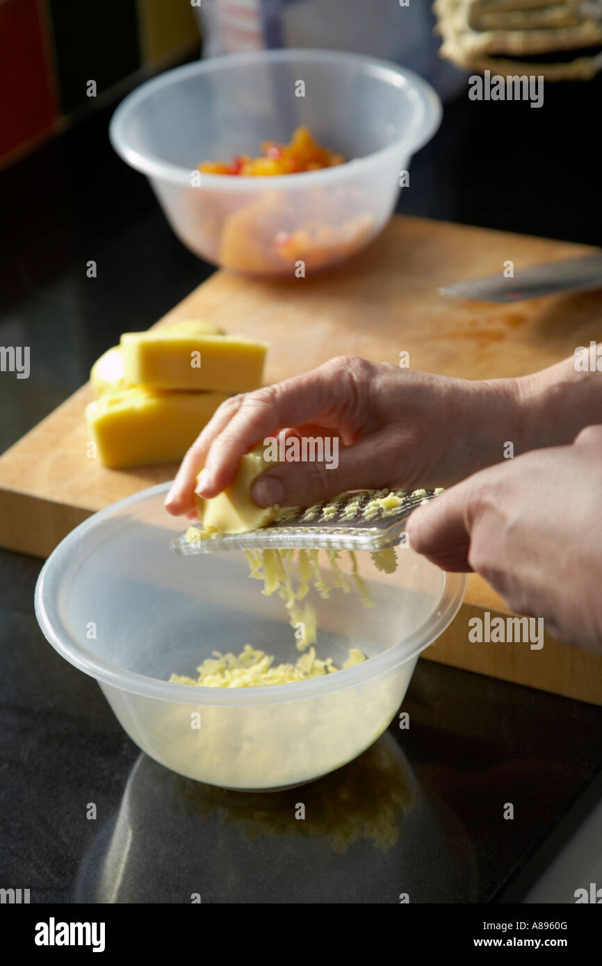Grating cheese into a bowl Stock Photo