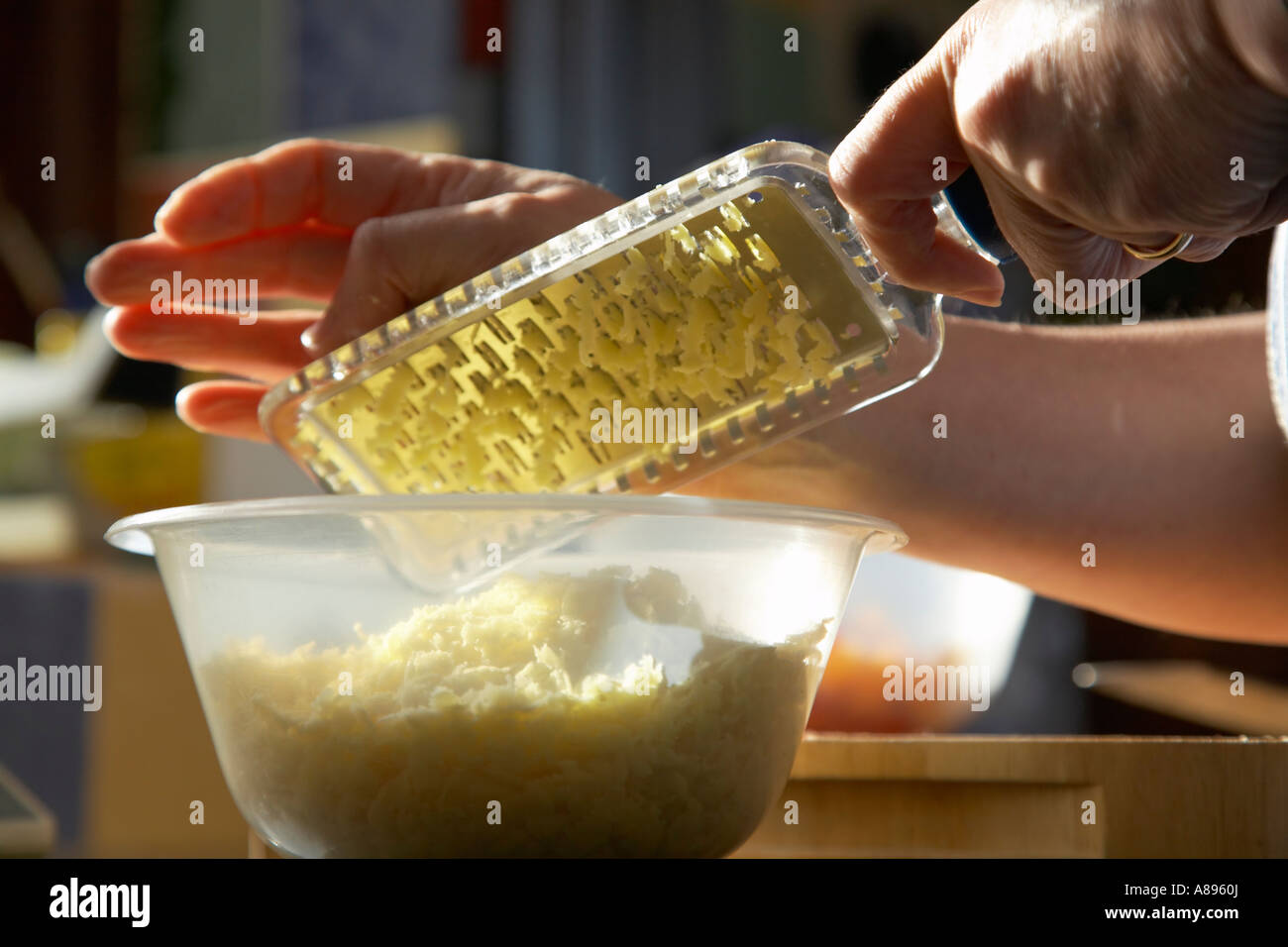 Grating cheese into a bowl Stock Photo
