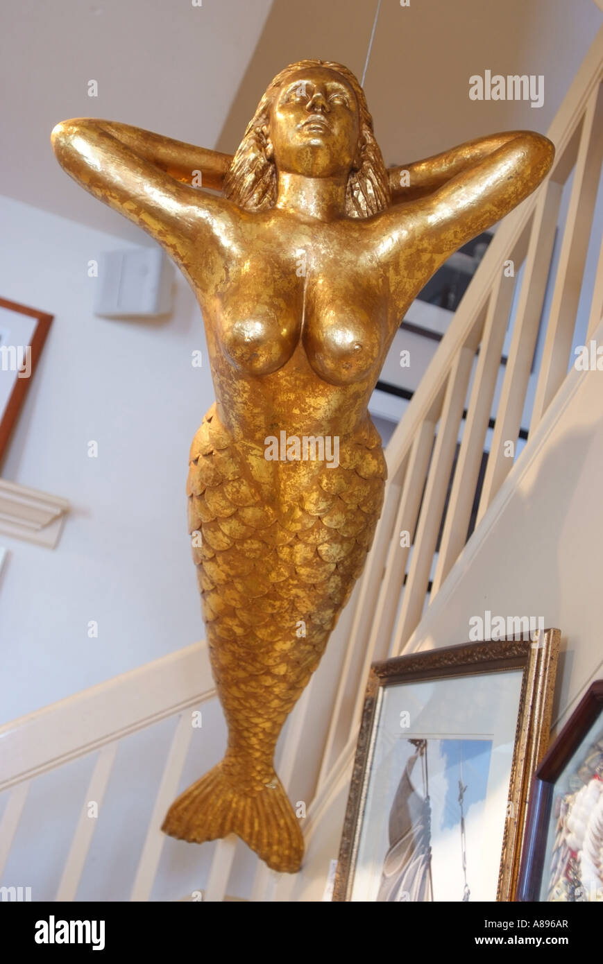 A gold life size mermaid adorns the ceiling of the Museum Store in old Annapolis Stock Photo