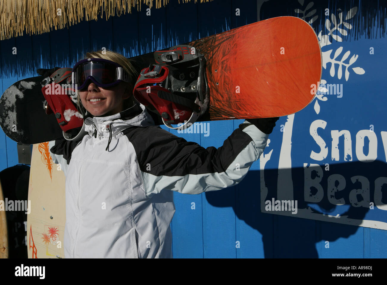 Women with googles holding a snowboard Stock Photo