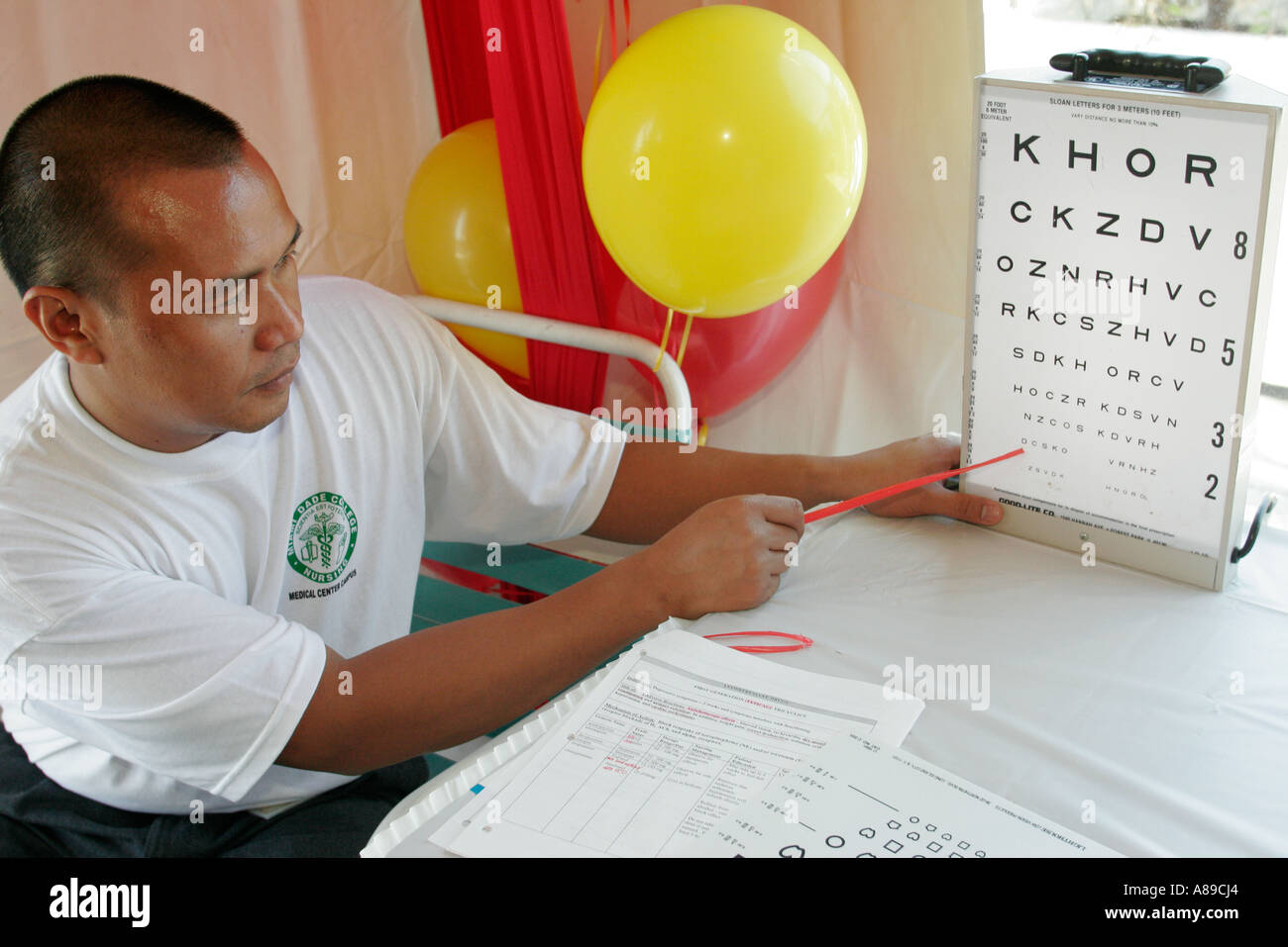 Miami Florida,Miami Dade College,school,campus,Medical Center Campus, Community Health Fair,Asian man,male student students,nurse,eye test  chart,FL0602 Stock Photo - Alamy