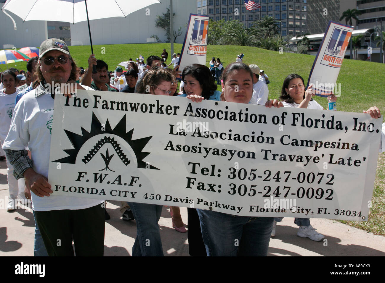 Florida Miami Bayfront Park immigrants rights protest Hispanic man men women carrying holding banner Farmworker Association Stock Photo