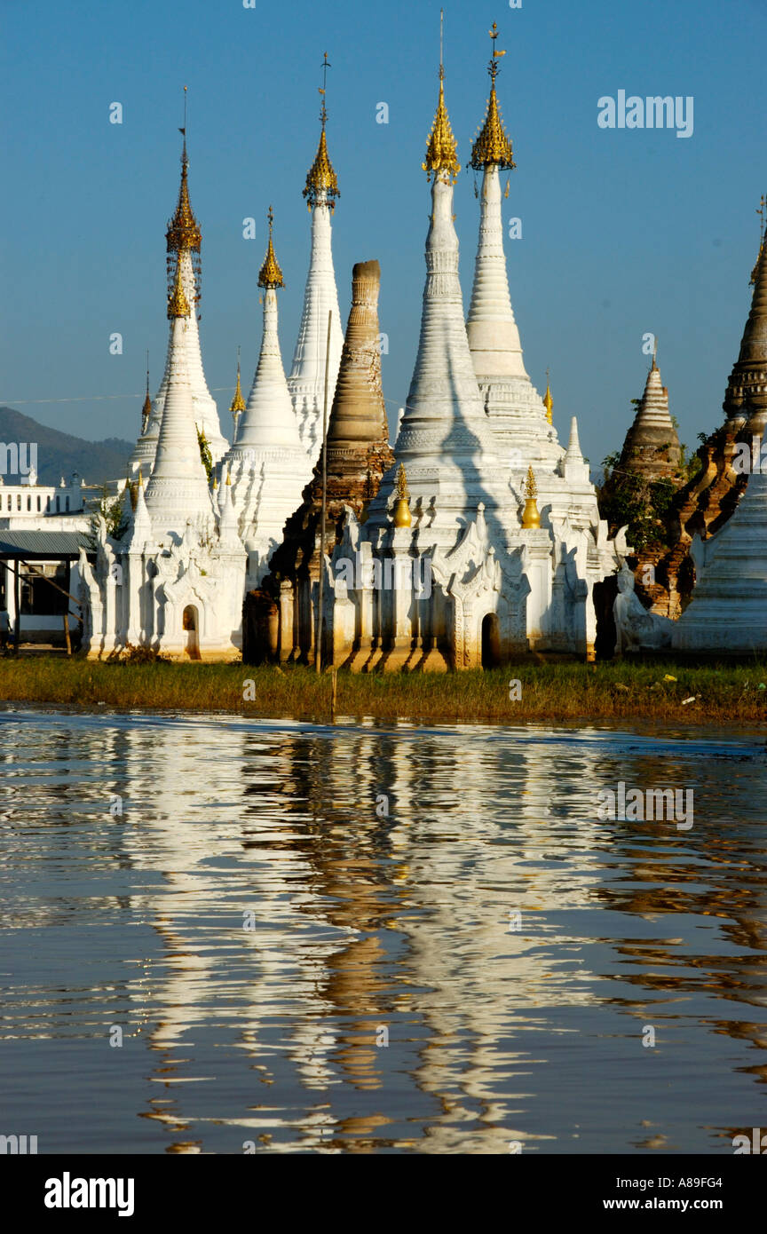 Slim stupas of Aung Min Ga Lar Paya reflect in the water Inle Lake Shan State Burma Stock Photo
