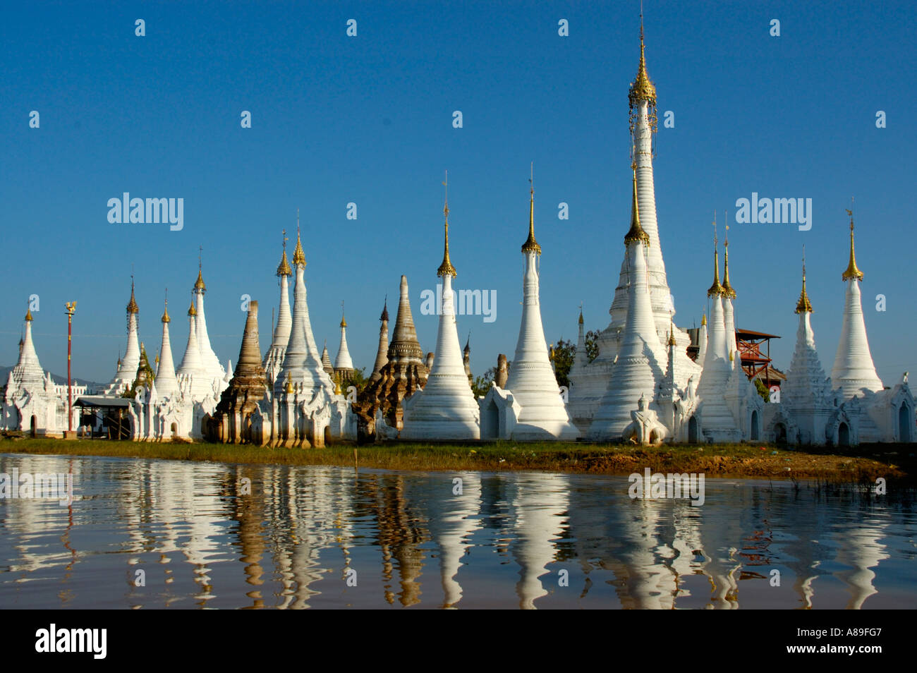 Slim stupas of Aung Min Ga Lar Paya reflect in the water Inle Lake Shan State Burma Stock Photo