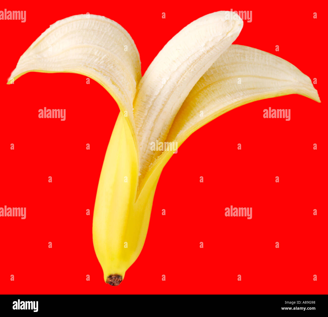 PEELED BANANA ON RED Stock Photo