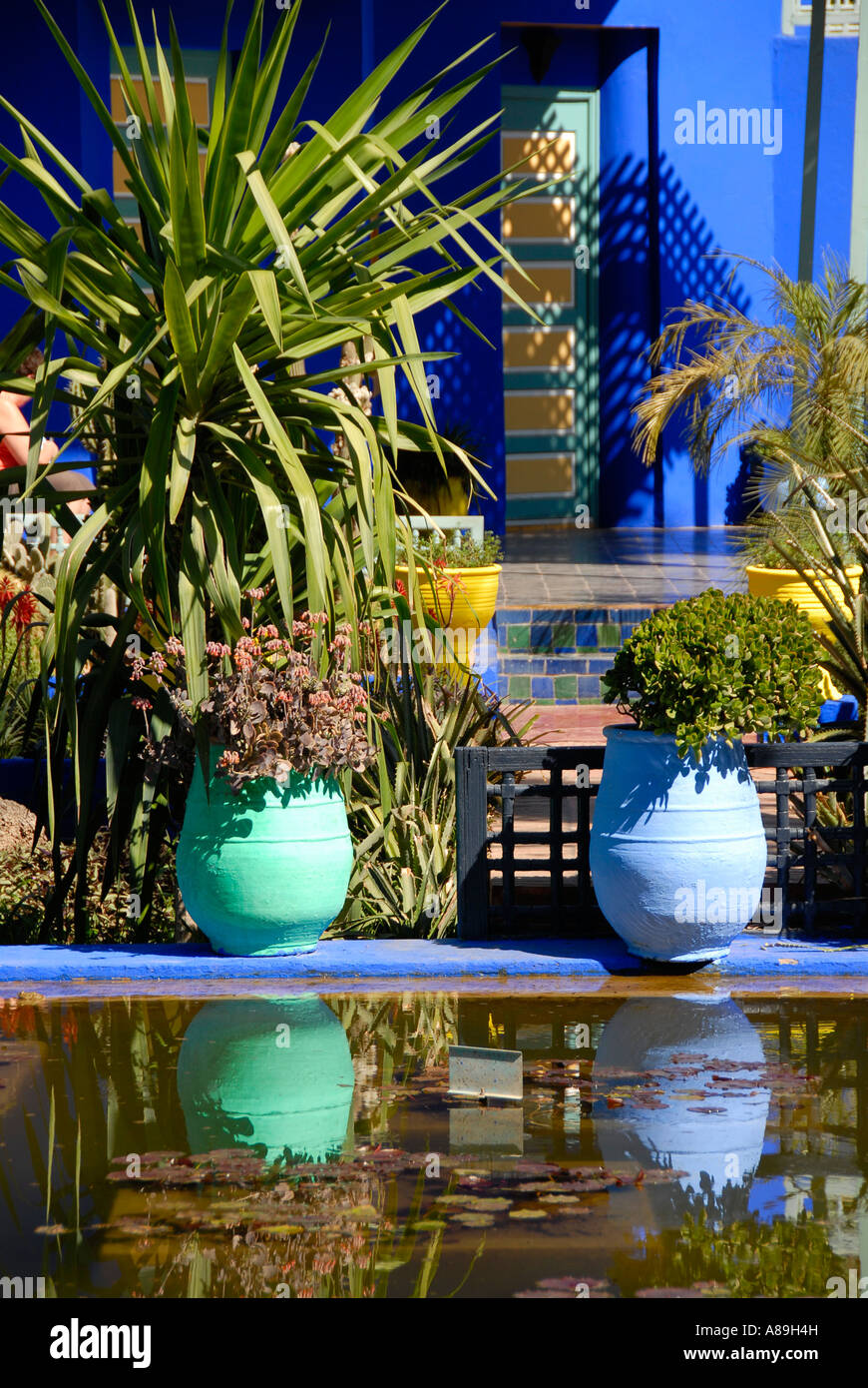 Shining luminous blue of flowerpots mirrors in water garden Jardin