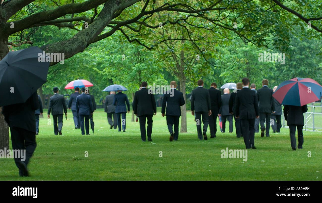 Men in smart city suits walking in Hyde Park London Stock Photo