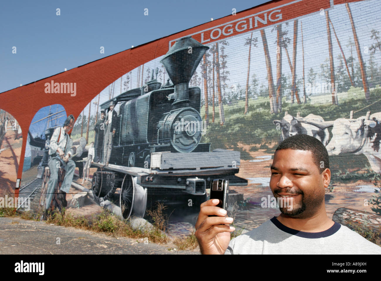 Dothan Alabama,Wiregrass Region murals,local history,logging,railroad,Black Blacks African Africans ethnic minority,adult adults man men male,cell pho Stock Photo