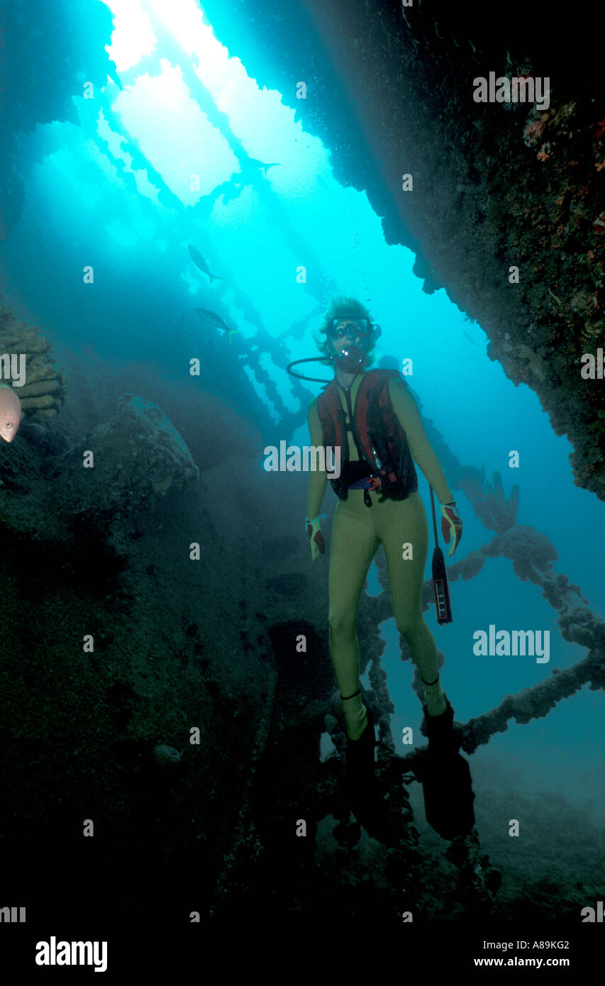 Underwater interior hold diver exploring interior of sunken ship Stock Photo